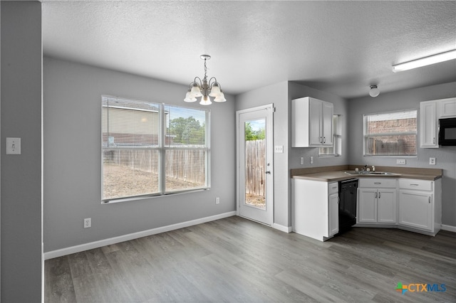 kitchen with black appliances, white cabinetry, hanging light fixtures, an inviting chandelier, and hardwood / wood-style flooring