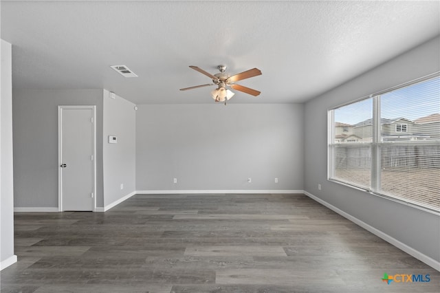 empty room with dark wood-type flooring, a textured ceiling, and ceiling fan