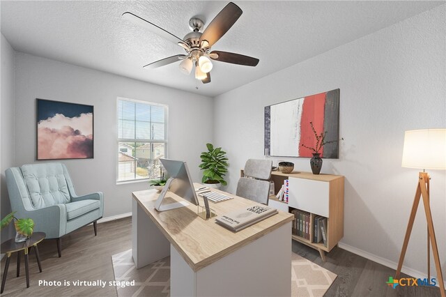 office space featuring a textured ceiling, dark wood-type flooring, and ceiling fan