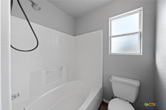 bathroom featuring washtub / shower combination and toilet