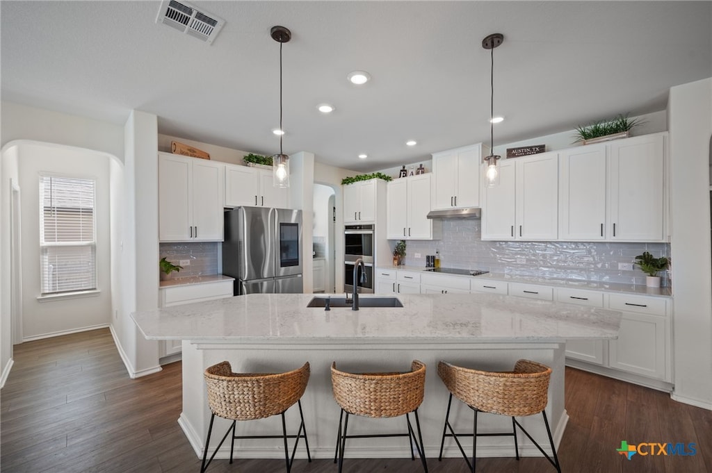 kitchen with sink, pendant lighting, white cabinets, and stainless steel appliances