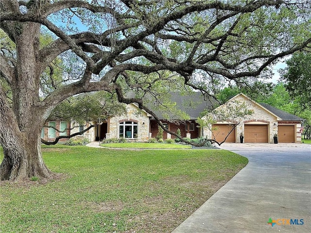 ranch-style home featuring stone siding, driveway, a garage, and a front yard