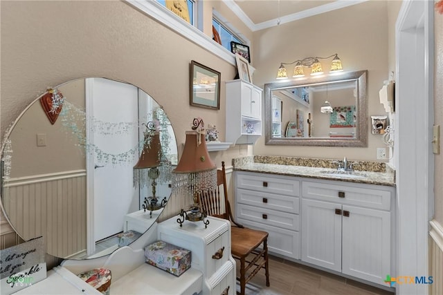 bathroom featuring vanity, crown molding, and wood finished floors