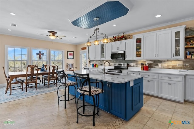 kitchen with visible vents, stainless steel appliances, white cabinets, crown molding, and backsplash