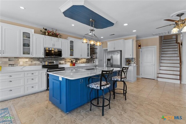 kitchen with appliances with stainless steel finishes, white cabinetry, and a sink