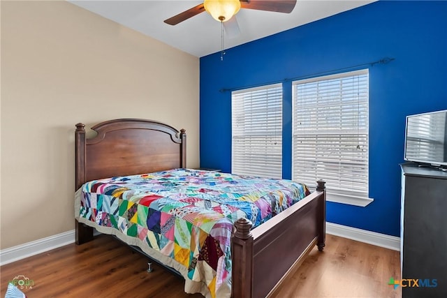 bedroom with ceiling fan, baseboards, and wood finished floors