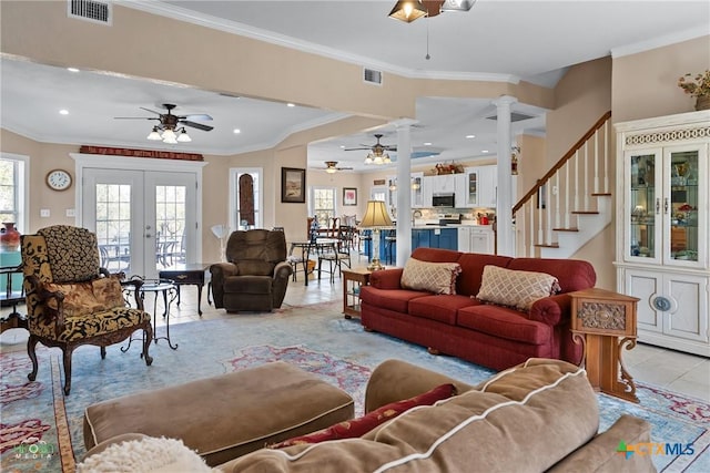 living area with a ceiling fan, visible vents, ornate columns, light tile patterned flooring, and crown molding