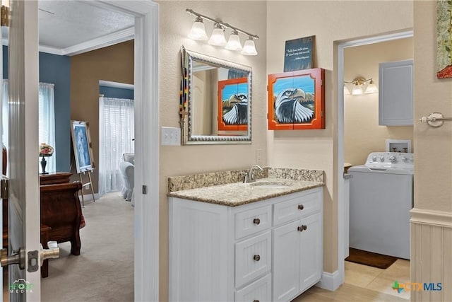 bathroom with vanity, washer / dryer, and ornamental molding