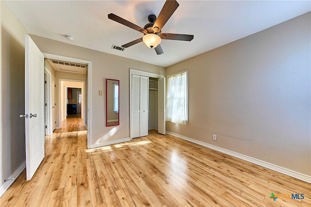 unfurnished bedroom featuring light hardwood / wood-style flooring, a closet, and ceiling fan