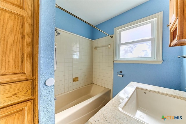 bathroom featuring sink and tiled shower / bath