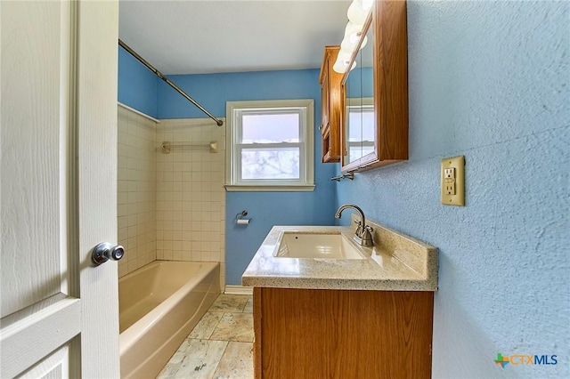 bathroom with tiled shower / bath and vanity