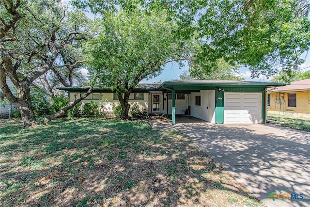 ranch-style house featuring a garage, a carport, and a front yard