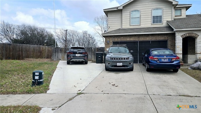 view of side of home featuring driveway, roof with shingles, an attached garage, fence, and brick siding