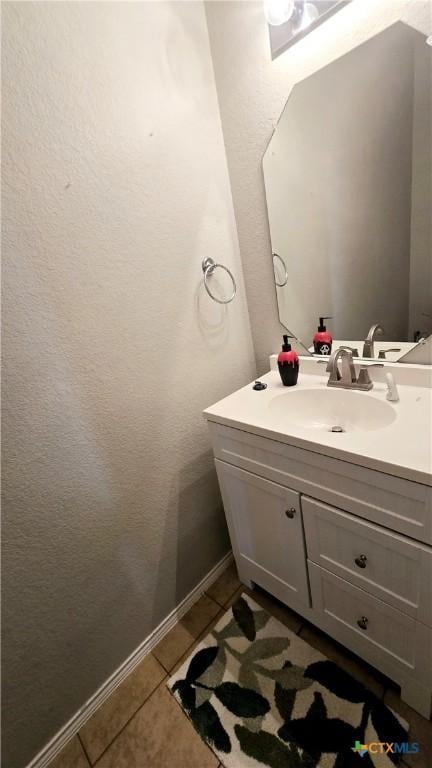 bathroom with baseboards, a textured wall, vanity, and tile patterned floors