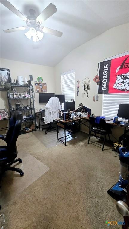 carpeted office featuring lofted ceiling and ceiling fan