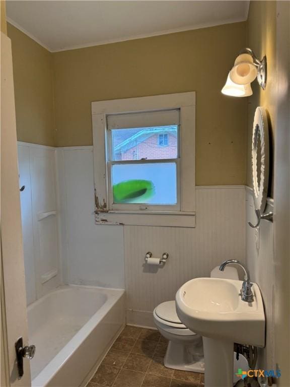 bathroom with a bathtub, a shower, a wainscoted wall, toilet, and ornamental molding