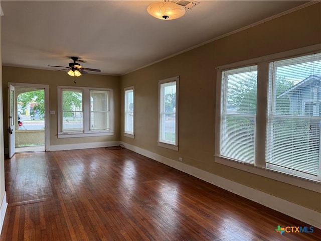 interior space featuring baseboards, a ceiling fan, wood-type flooring, and ornamental molding