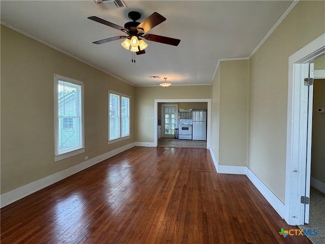 spare room featuring baseboards, ornamental molding, and wood finished floors