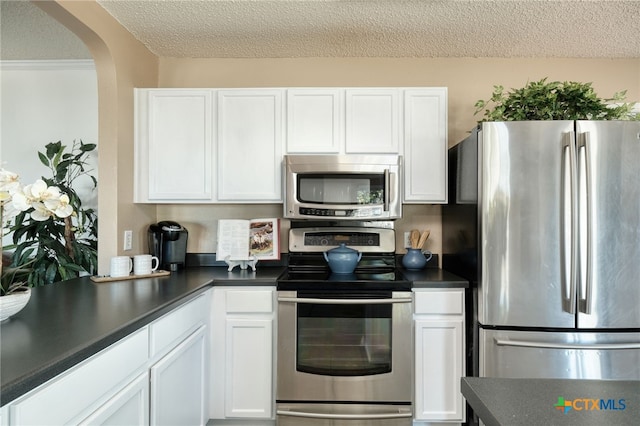 kitchen featuring white cabinets, a textured ceiling, and stainless steel appliances