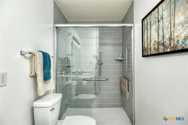 bathroom with a shower with shower door, a textured ceiling, and toilet