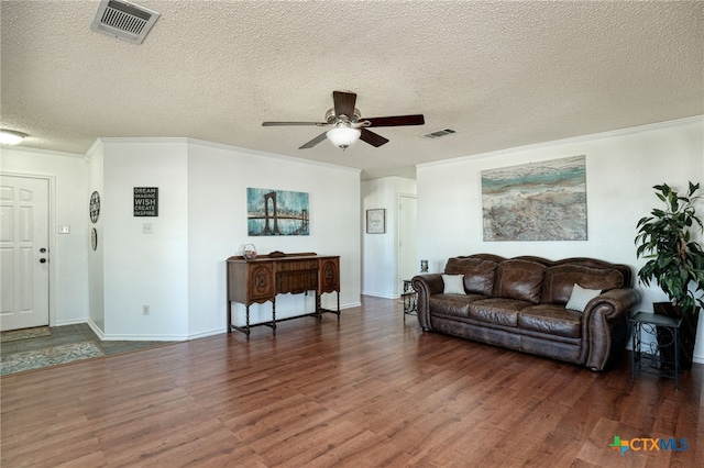 living room with dark hardwood / wood-style floors, ceiling fan, crown molding, and a textured ceiling