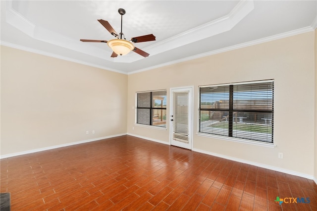 unfurnished room with hardwood / wood-style floors, ceiling fan, a raised ceiling, and ornamental molding