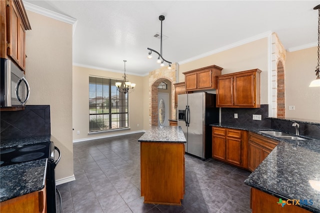 kitchen with backsplash, hanging light fixtures, sink, and stainless steel appliances