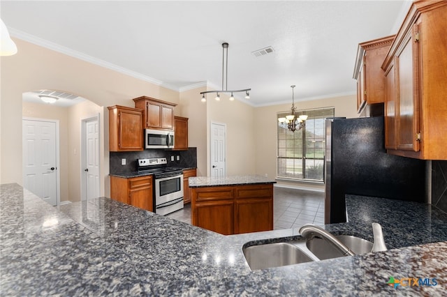 kitchen featuring stainless steel appliances, sink, tasteful backsplash, crown molding, and decorative light fixtures