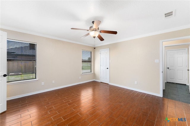 spare room with dark wood-type flooring, crown molding, ceiling fan, and plenty of natural light