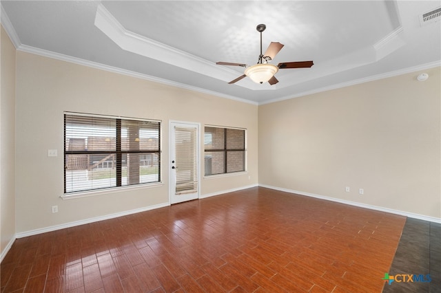 spare room with dark hardwood / wood-style flooring, ceiling fan, a raised ceiling, and crown molding