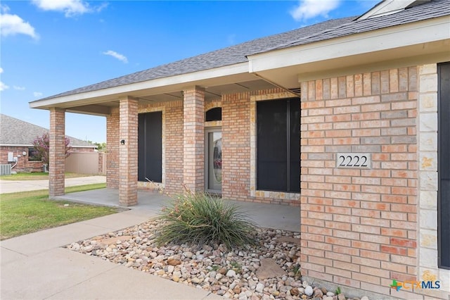 2222 Sparrow Rd, Killeen, TX 76542 - entrance to property featuring brick siding, central air condition unit, and roof with shingles