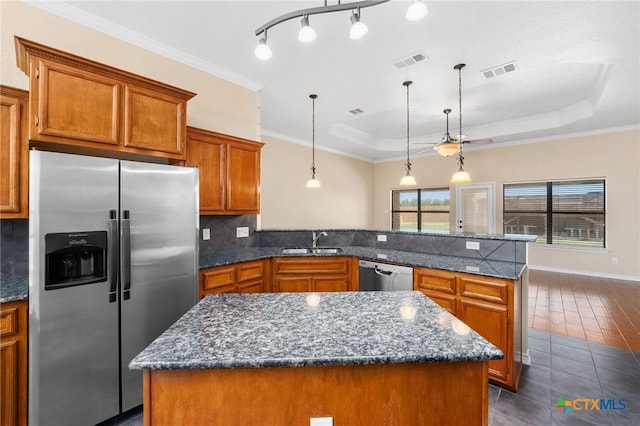 2222 Sparrow Rd, Killeen, TX 76542 - kitchen featuring stainless steel appliances, a sink, a peninsula, brown cabinetry, and tasteful backsplash