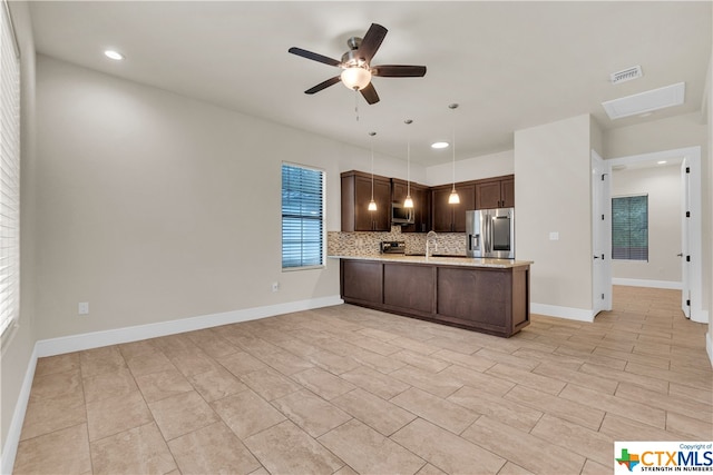 kitchen featuring stainless steel appliances, kitchen peninsula, ceiling fan, backsplash, and pendant lighting