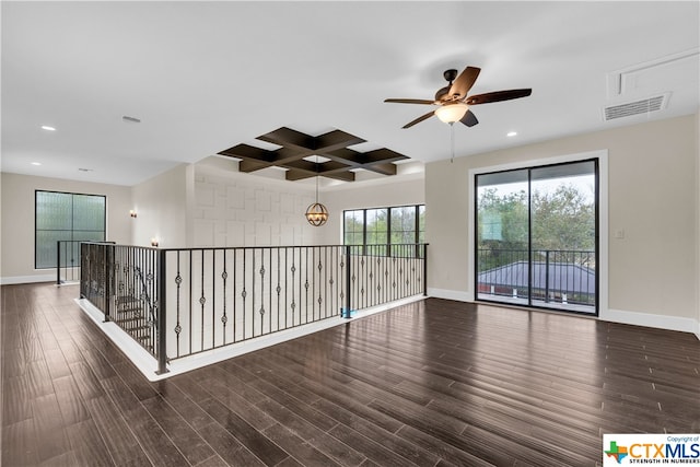 empty room featuring ceiling fan, beam ceiling, dark hardwood / wood-style flooring, and coffered ceiling