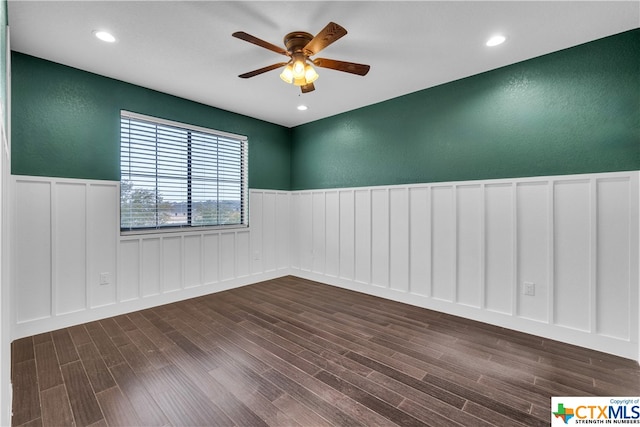 spare room featuring dark hardwood / wood-style flooring and ceiling fan