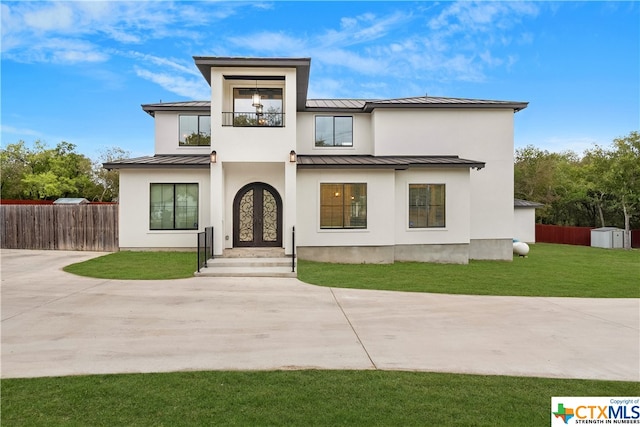 view of front of property with a balcony and a front yard