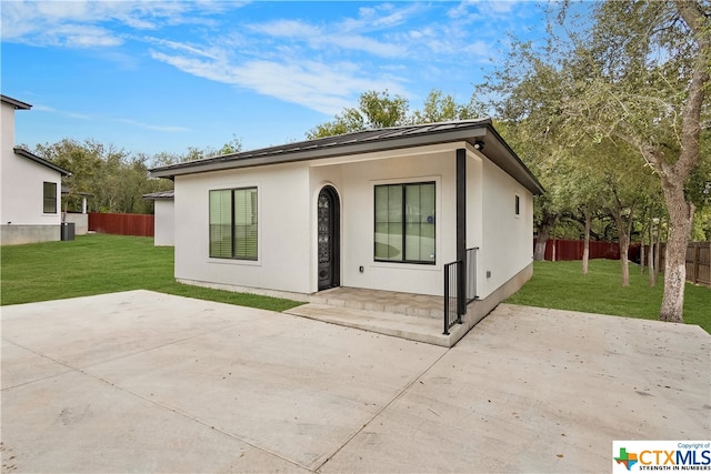 rear view of house featuring a patio and a yard