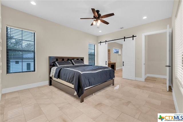 bedroom featuring a barn door and ceiling fan