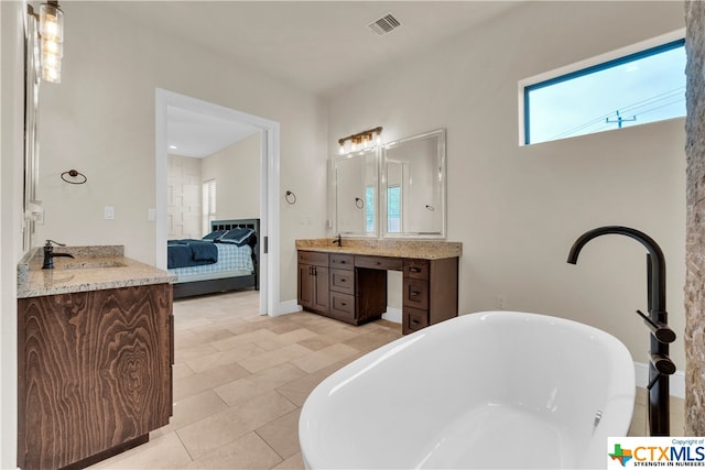 bathroom featuring a bathtub, vanity, and tile patterned floors