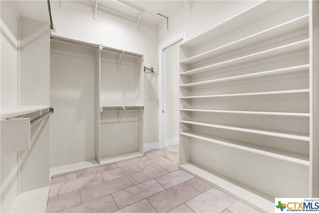 spacious closet featuring light tile patterned floors