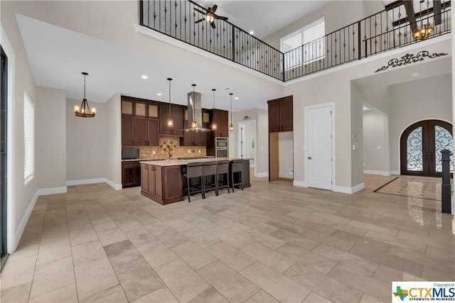12312 White Birch St, San Antonio, TX 78245 - kitchen with tasteful backsplash, light countertops, a chandelier, island exhaust hood, and french doors