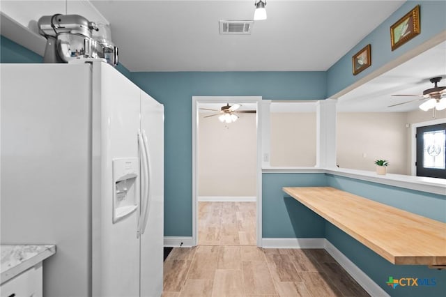 kitchen with white refrigerator with ice dispenser and ceiling fan