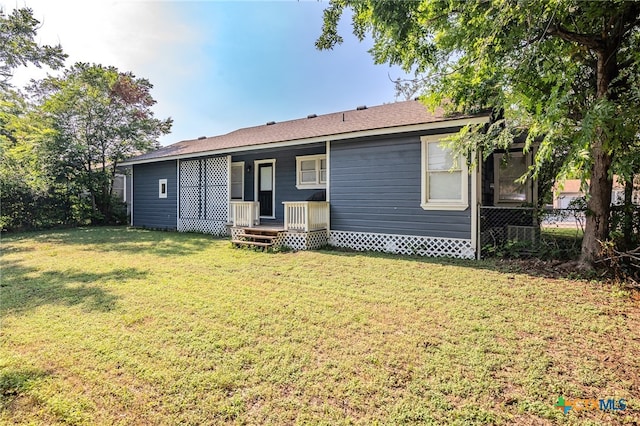 rear view of property with a lawn