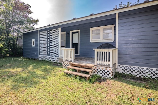 view of front of property featuring a deck and a front lawn