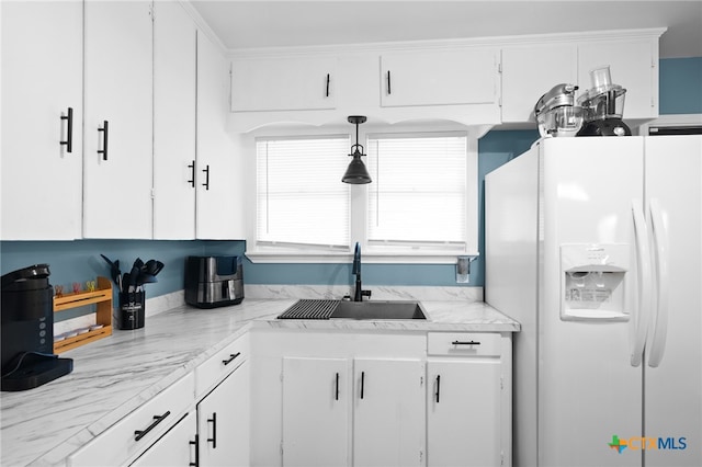 kitchen featuring white refrigerator with ice dispenser, sink, light stone countertops, and white cabinets