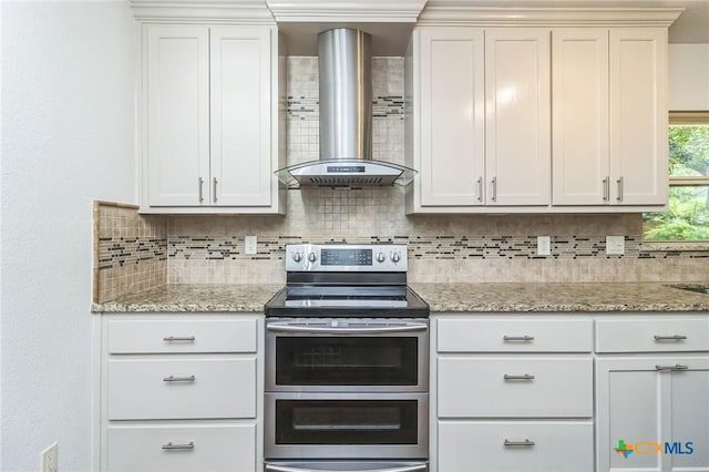 102 Norcrest Dr, San Marcos, TX 78666 - kitchen featuring range with two ovens, wall chimney range hood, tasteful backsplash, and light stone counters