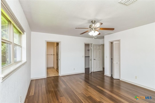 102 Norcrest Dr, San Marcos, TX 78666 - unfurnished bedroom with wood finished floors, baseboards, a ceiling fan, and ensuite bath