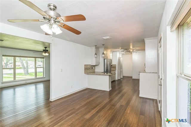 102 Norcrest Dr, San Marcos, TX 78666 - kitchen featuring freestanding refrigerator, dark wood-type flooring, a ceiling fan, a peninsula, and light stone counters