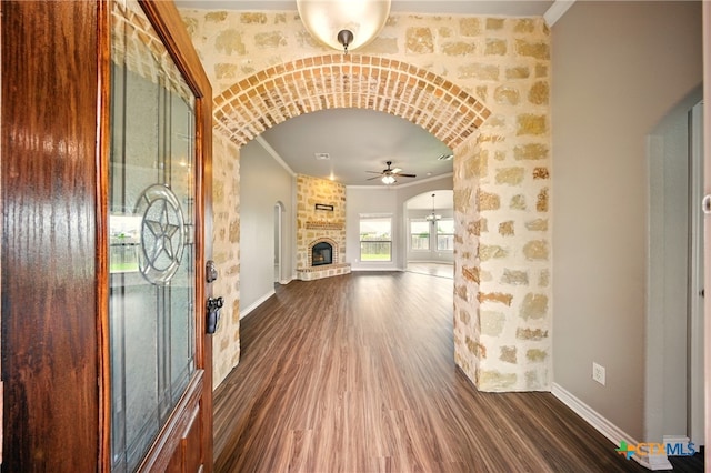 412 Coventry Dr, Temple, TX 76502 - foyer featuring arched walkways, a ceiling fan, dark wood-style floors, a fireplace, and crown molding