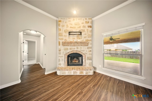 412 Coventry Dr, Temple, TX 76502 - unfurnished living room with ornamental molding, arched walkways, wood finished floors, a fireplace, and a ceiling fan